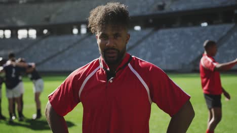 male rugby player standing with hands on hip in stadium 4k