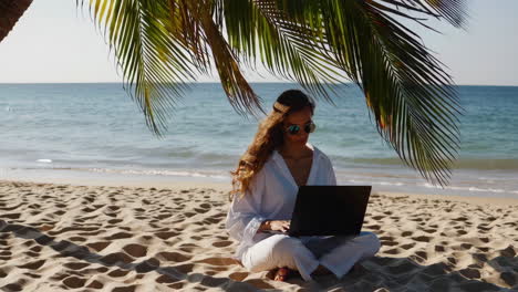 woman working on laptop at the beach
