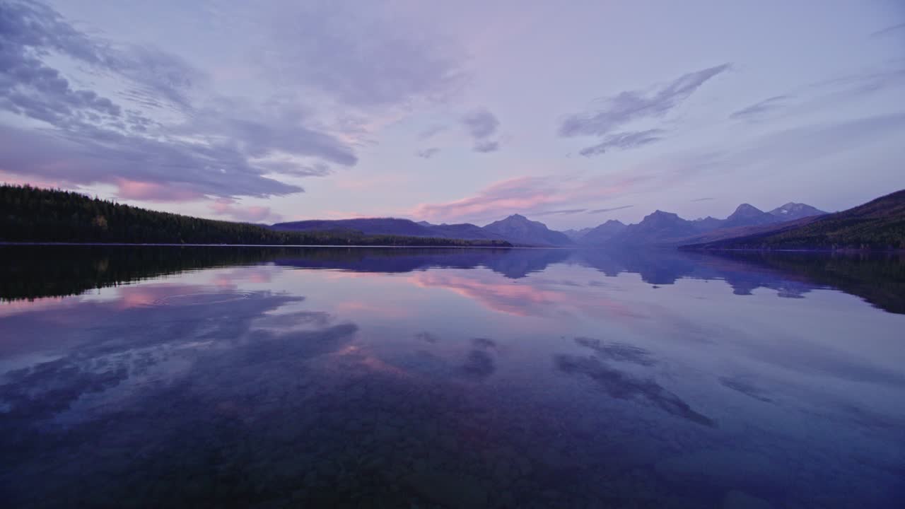 escena de otoño mirando a través del lago en la colorida puesta de sol en el lago mcdonald en montana