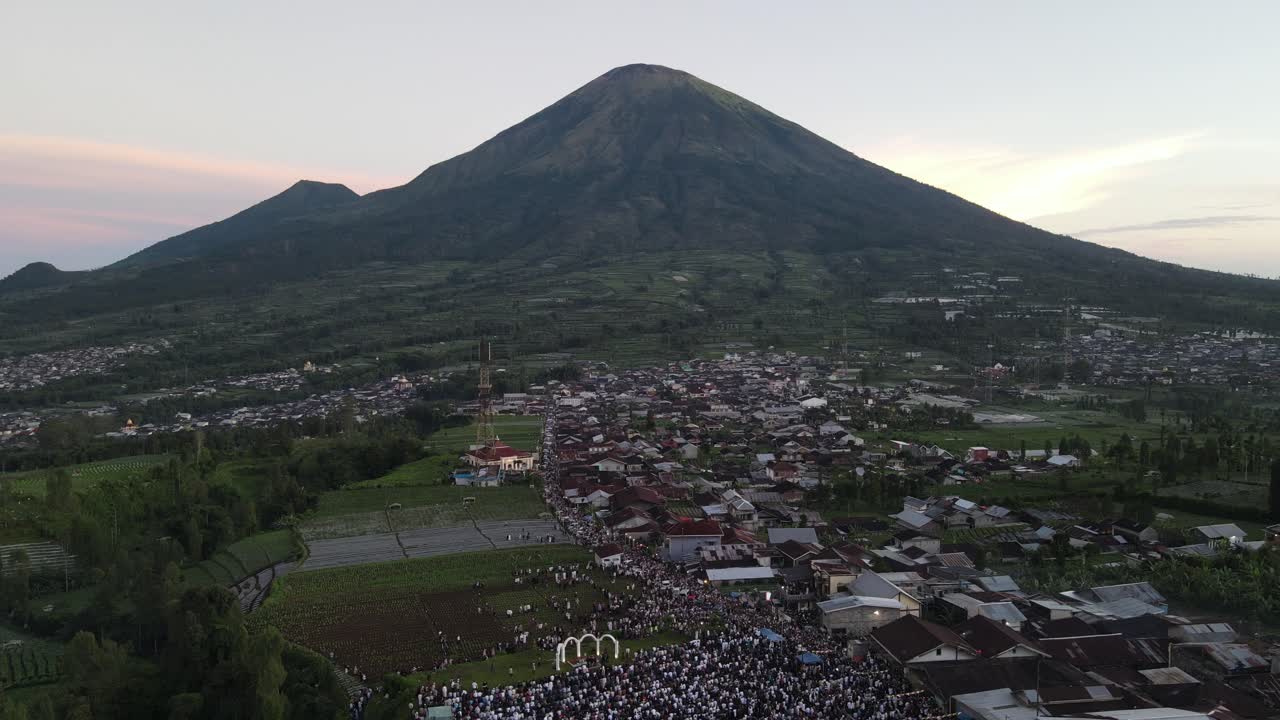 Aerial view, thousands of worshipers praying Eid al-Adha or Eid al-Fitr in Garung Village, Wonosobo. Praying with the most beautiful view of Mount Sumbing and Sindoro.