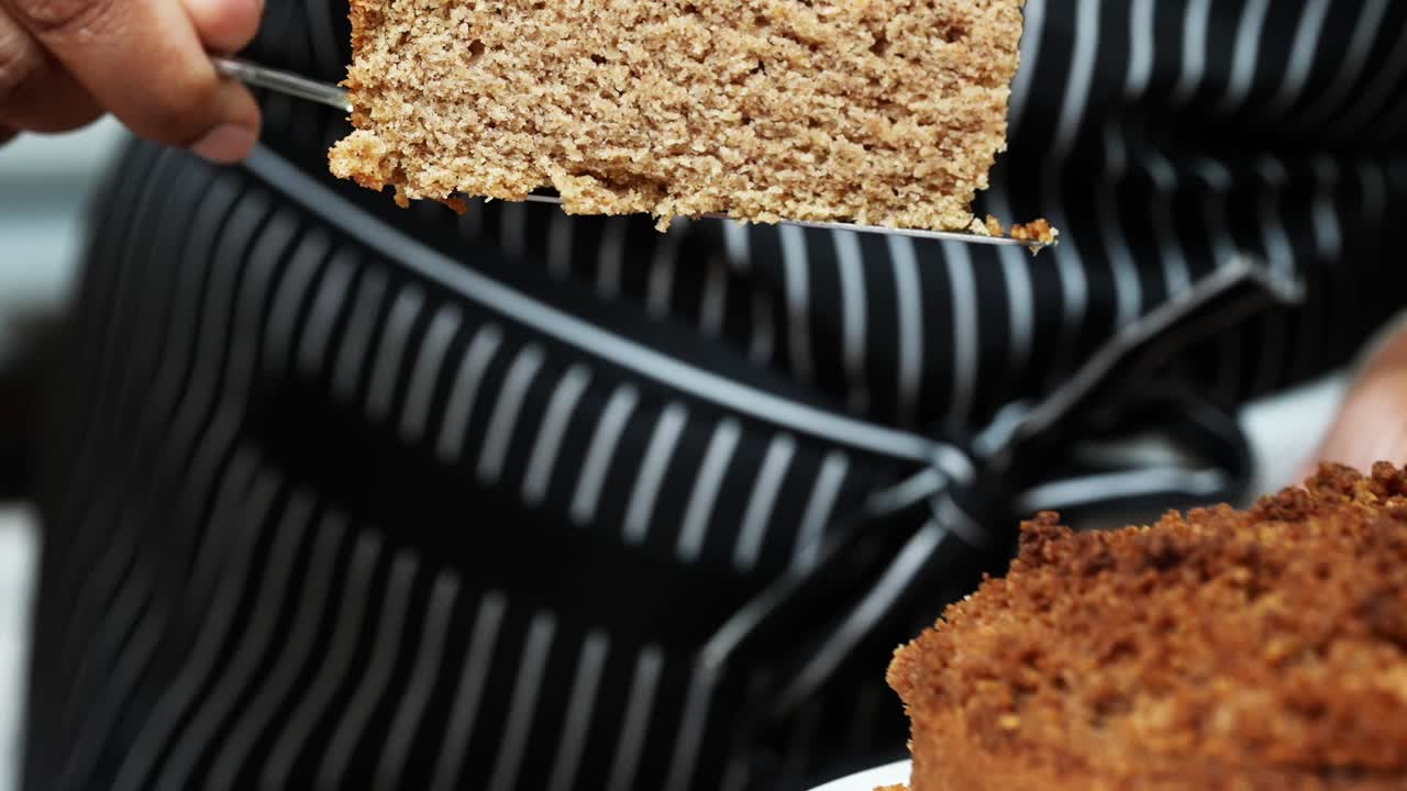 Dishing up a large slice of freshly baked moist homemade vegan coffee cake - slow motion