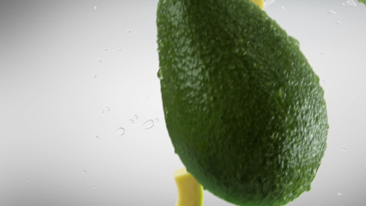 회색 배경에 떨어지는 조각과 스플래시와 함께 아보카도