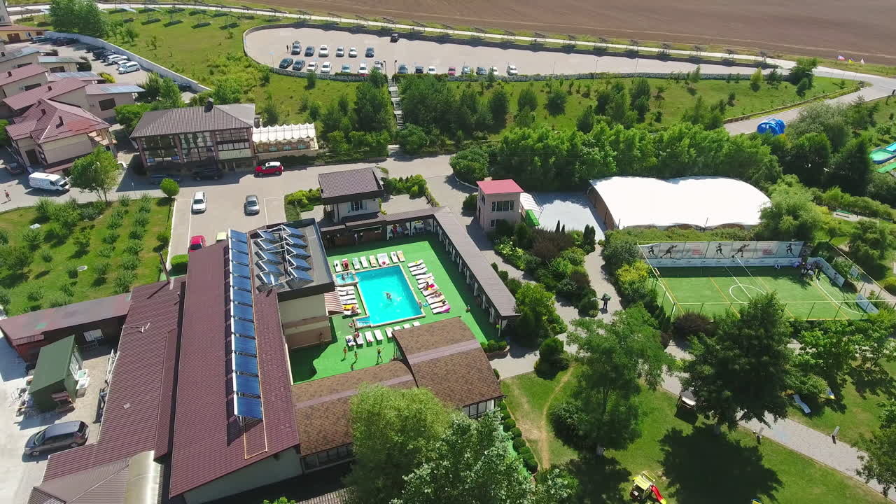 Green, clean and well-structured territory of spa-resort outside the city. Luxury outdoor swimming pool and relaxing zone around it. Birdseye view.