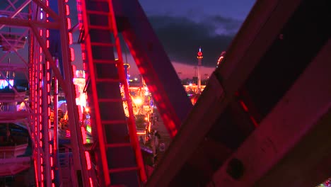 view from a ferris wheel at dusk of a carnival amusement park or state fair