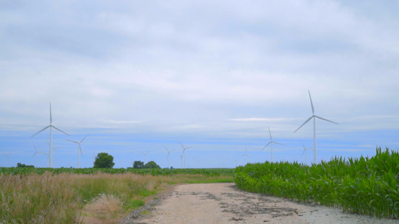 풍력 터빈과 구름 하늘 아래의 시골 도로. 농장 필드에서 풍력 터빈