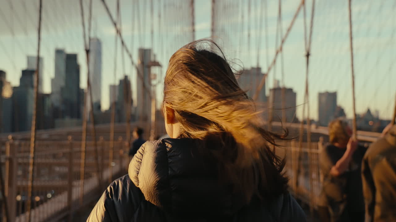 Woman Walking on Brooklyn Bridge at Sunset