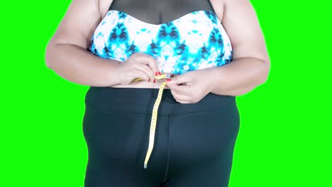 closeup of overweight woman measuring waist