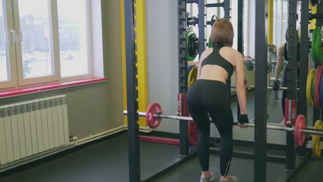 woman performing deadlift in gym