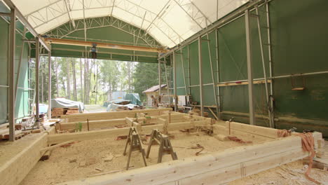 wide shot of timber frame for log cabin being assembled in workshop