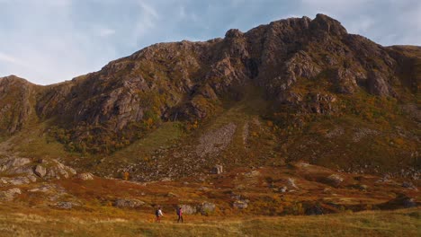 wide shot of hikers walking through a vibrant mountain landscape in vestarelen, norway