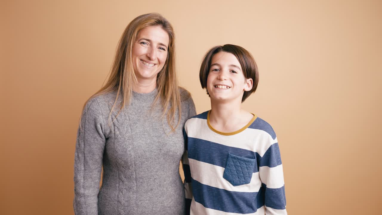 Glückliche Mutter und Sohn lächeln zusammen auf einem Studiofoto