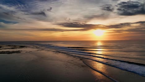 Clip-De-Drone-Que-Muestra-Una-Brillante-Puesta-De-Sol-Dorada-Sobre-Las-Olas-Del-Océano-En-Un-Punto-De-Ruptura-En-Indonesia