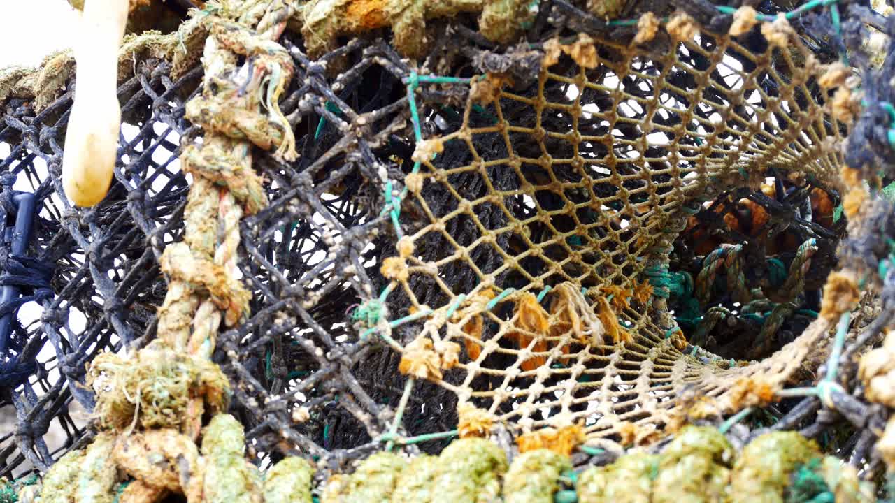 Nasse per aragoste vuote dell'industria della pesca impilate, primo piano, carrellata a sinistra, guardando in alto
