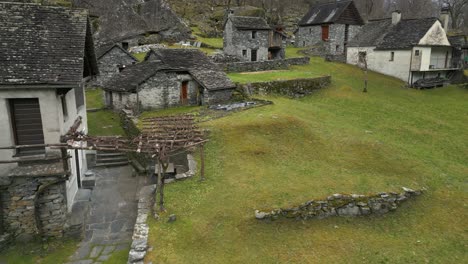 Drone-flying-through-a-village-in-Cavergno,-situated-in-the-district-of-Vallemaggia,-bordering-Italy-in-the-canton-of-Ticino-in-Switzerland