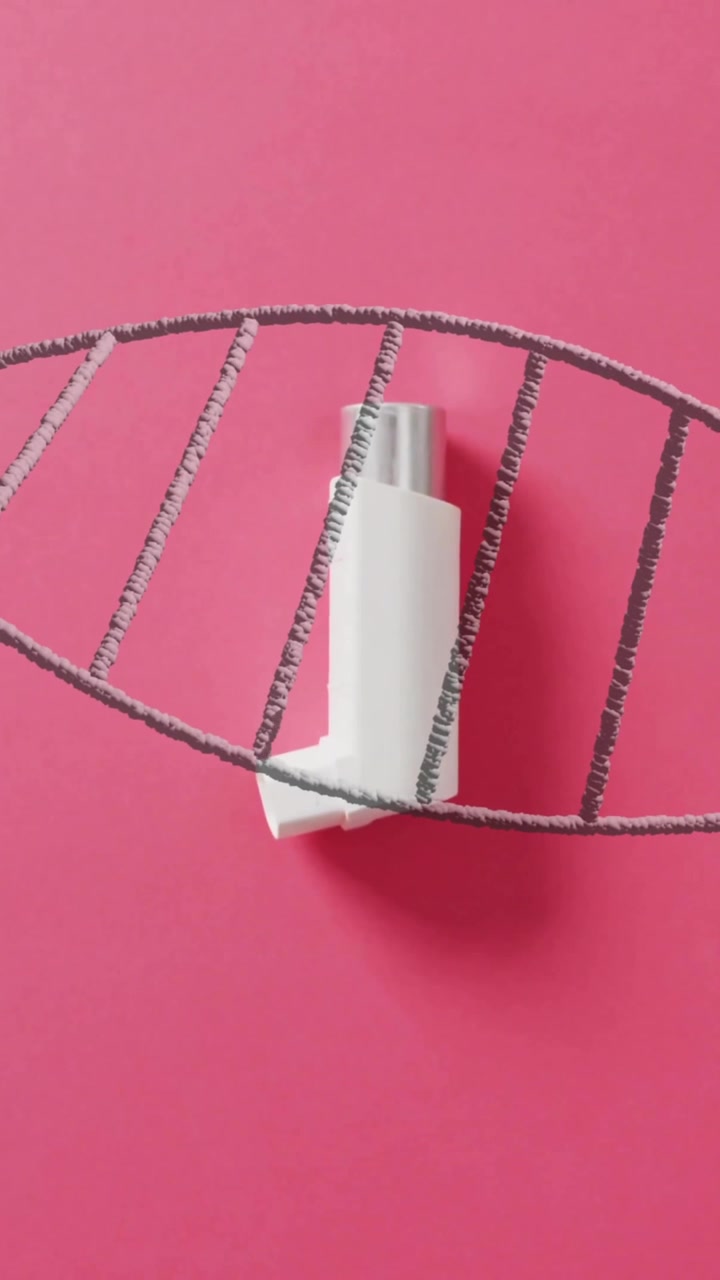 Inhalaattori DNA-juosteanimaation sisällä vaaleanpunaisella taustalla.