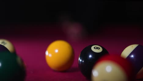 eye level slow motion frontal shot of man hitting cue ball and breaking rack on the pool table