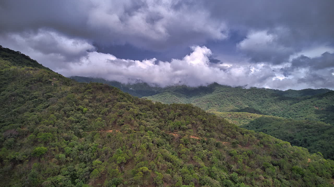 hiperlapso con una colina en primer plano, con nubes dramáticas de rápido movimiento, revelando la cordillera de la sierra madre occidental