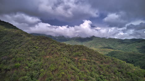 Hiperlapso-Que-Presenta-Una-Colina-En-Primer-Plano,-Con-Nubes-Dramáticas-Que-Se-Mueven-Rápidamente,-Revelando-La-Cordillera-De-La-Sierra-Madre-Occidental