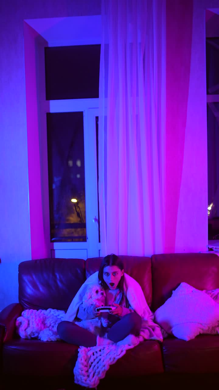 mujer y perro jugando videojuegos por la noche