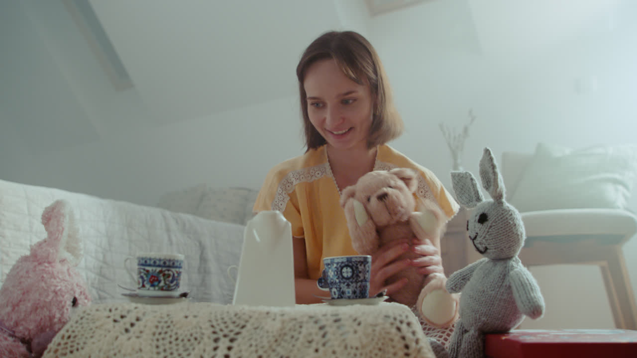 A girl playing with dolls in her room