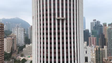 plataforma de limpieza de ventanas que desciende en el rascacielos de hong kong en un día sombrío