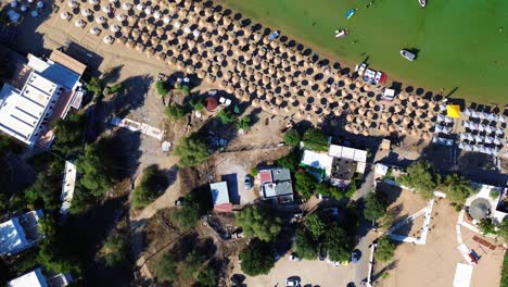 Pueblo-De-Lindos-En-Rodas,-Grecia-Con-La-Acrópolis-De-Lindos,-Casas-Y-El-Mar-Mediterráneo-Durante-El-Día-Filmado-Con-El-Dron