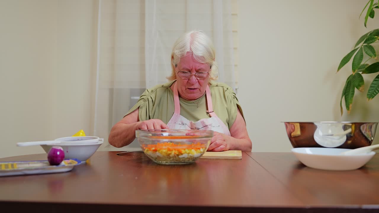 Close up of grandmother preparing homemade salad with carrots and potatoes