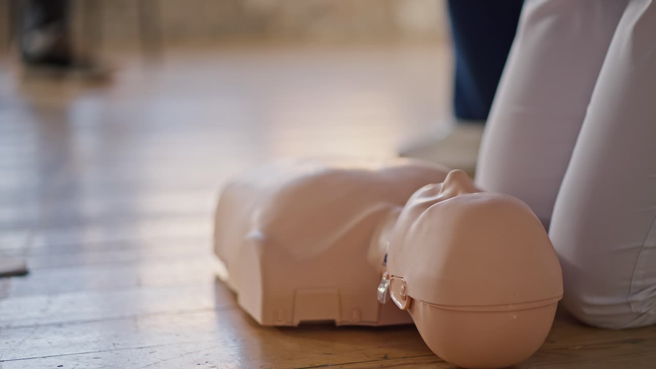 fotografía de primer plano desde abajo: una médica profesional lleva a cabo una formación práctica en atención médica, haciendo respiración artificial en un maniquí utilizando una bolsa de reanimación de ambu para el público