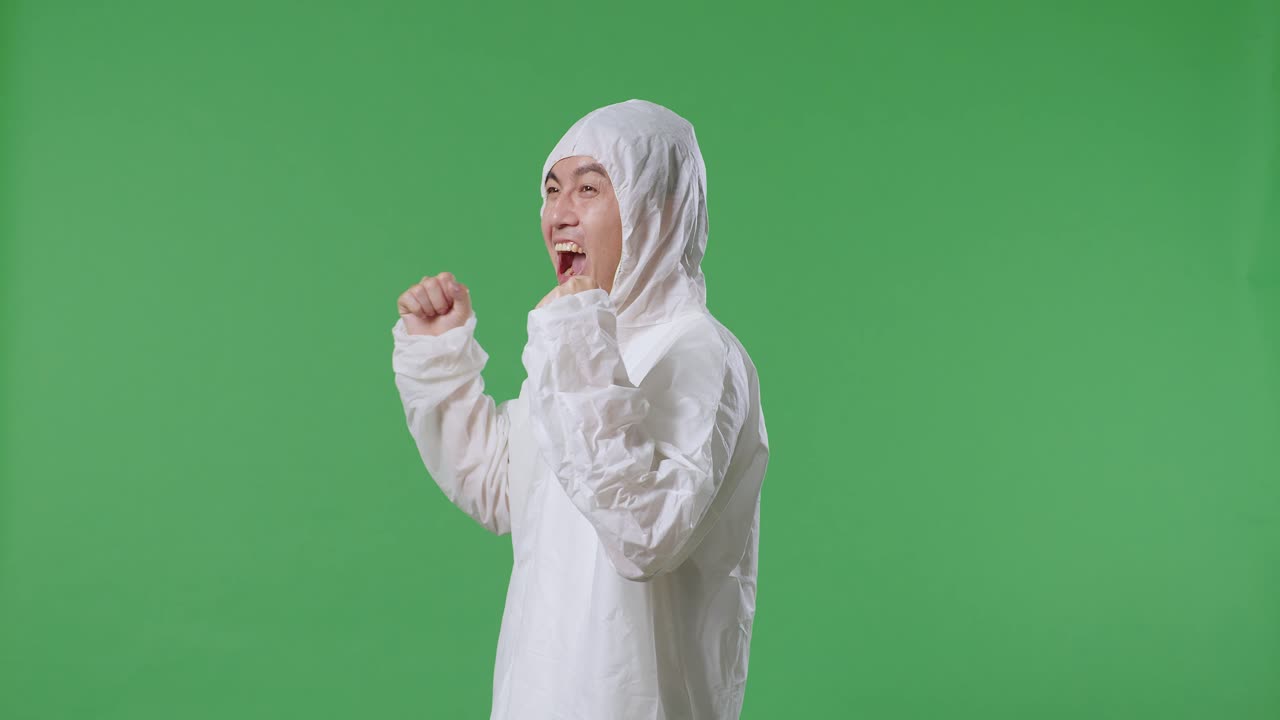 녹색 스크린 배경에 서서 성공을 축하하는 아시아 남성 과학자의 측면 시각