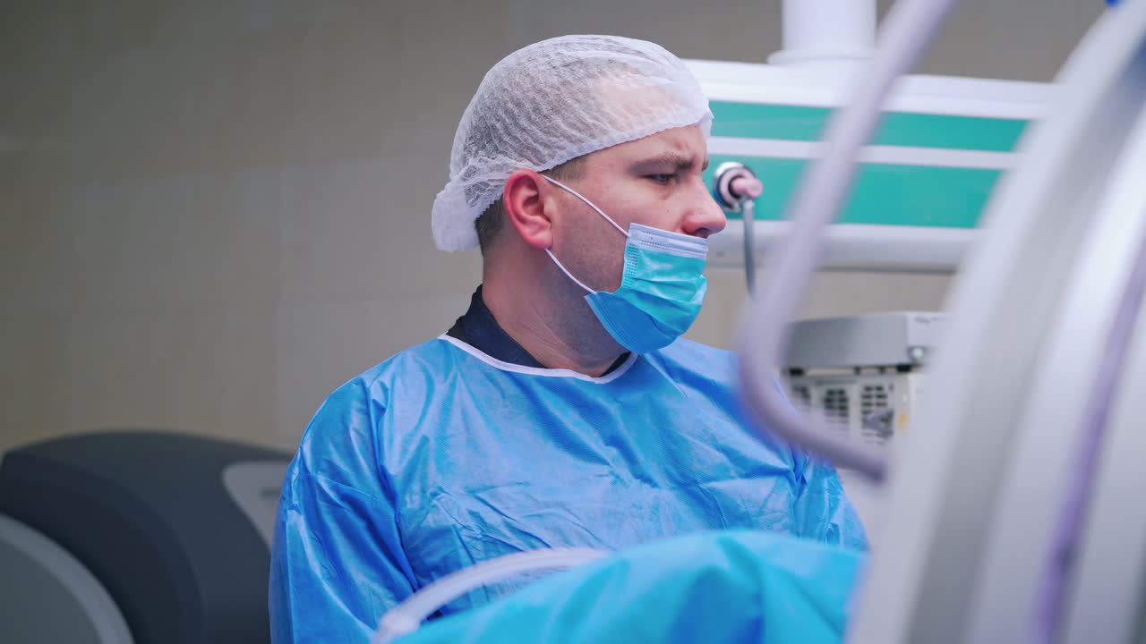 Nervous surgeon in the operating room. Doctor in blue mask and uniform looking aside during the operation process. Medical concept.
