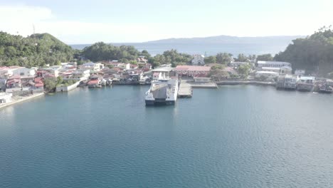 Drone-Flying-Towards-A-Local-Fastcat-Ferry-Boat-Docked-At-The-Pier-Of-A-Tropical-Island-In-Southern-Leyte,-Philippines-During-COVID-19-Pandemic---Aerial-Drone-Forward-Shot