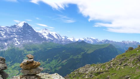 Torre-De-Piedra-Con-Hermosos-Paisajes-Montañosos-Y-Picos-Montañosos-Cubiertos-De-Nieve-Y-Hierba-Verde-Durante-El-Verano