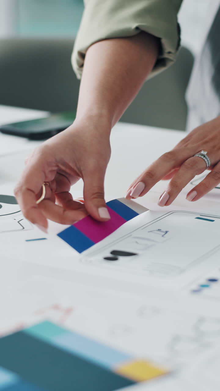 Close-up of Designer's Hands Arranging Color Swatches on a Project