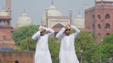 two muslim men wearing cap and preparing to pray at a mosque