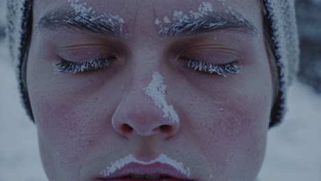 snow and ice gradually accumulating on peaceful human face, closed eyes reflecting profound serenity amid extreme winter landscape, highlighting silent endurance against freezing temperatures