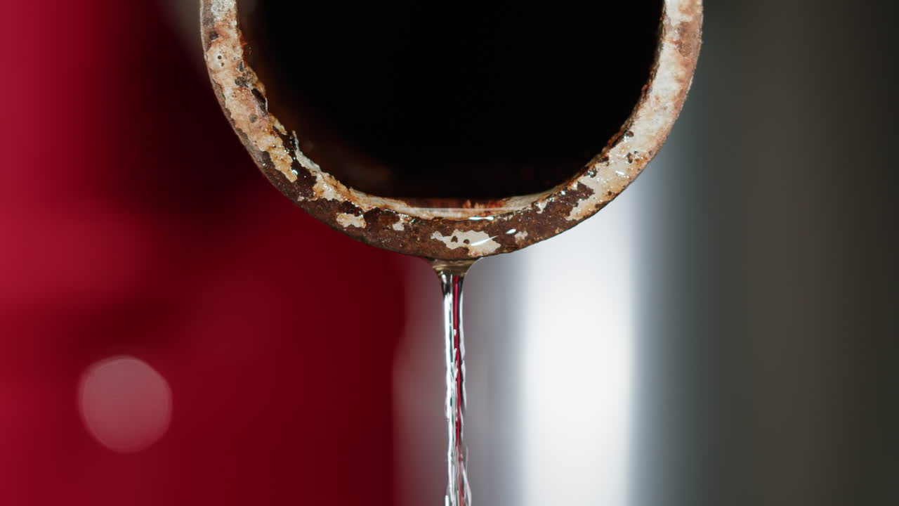 Acqua che gocciola da un tubo arrugginito