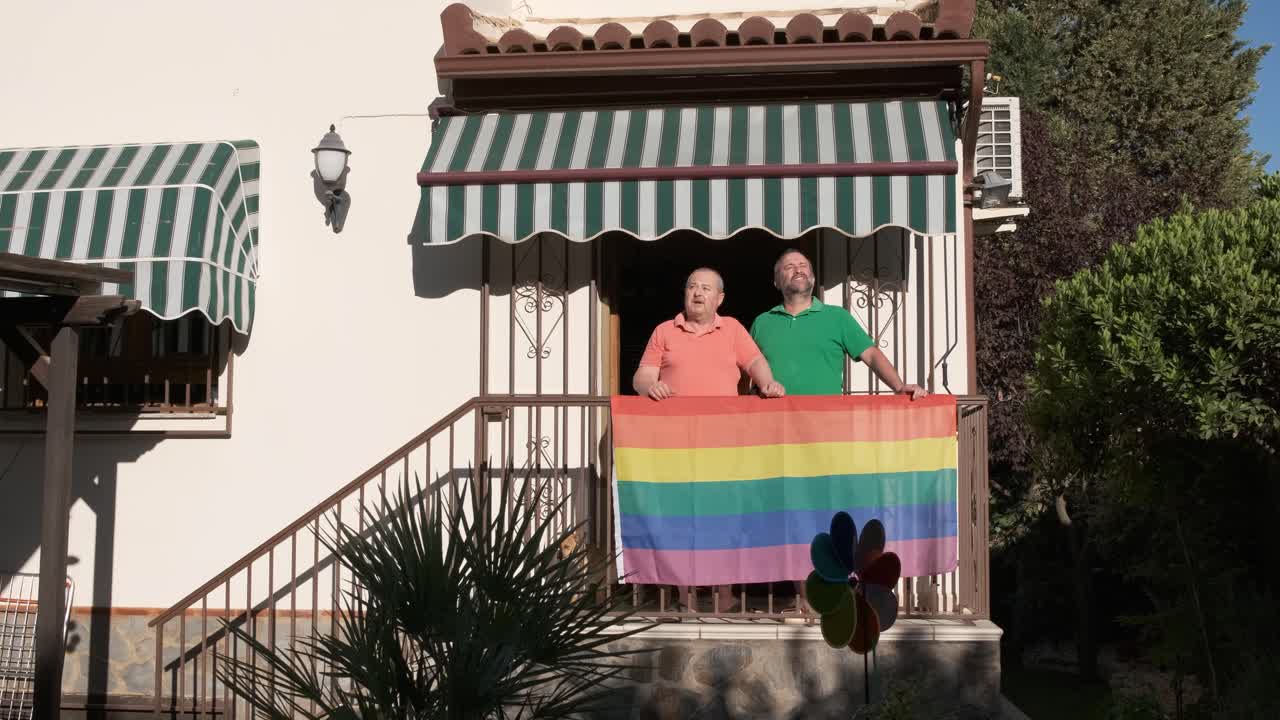 Men on balcony with LGBT flag