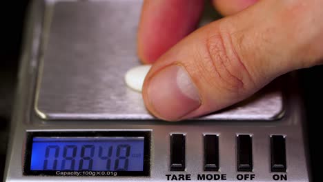 weighing a pill on a digital scale