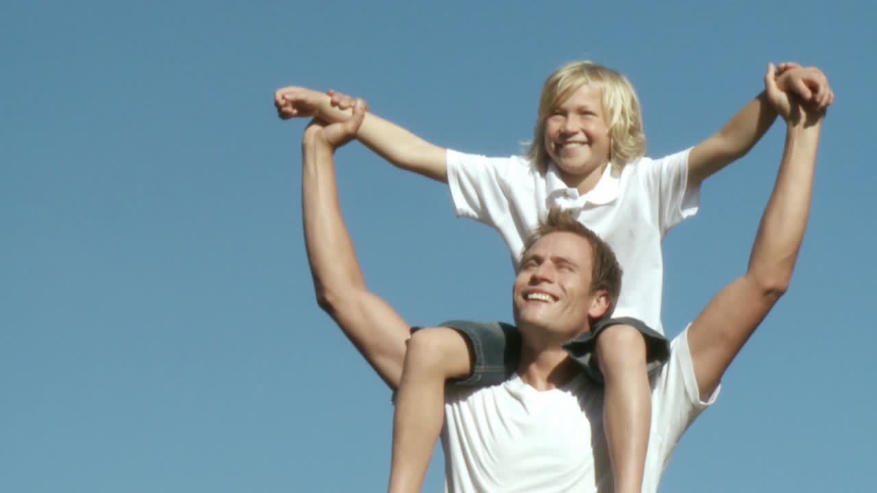 Padre orgulloso con su hijo sobre sus hombros