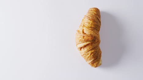 Video-of-close-up-of-croissant-with-copy-space-on-white-background