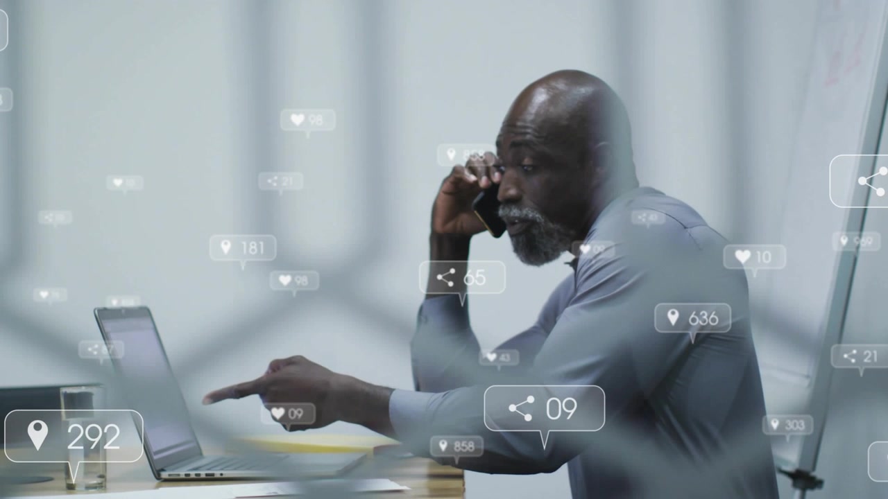 Male marketer holding smartphone and tapping trackpad while generating icons for digital marketing