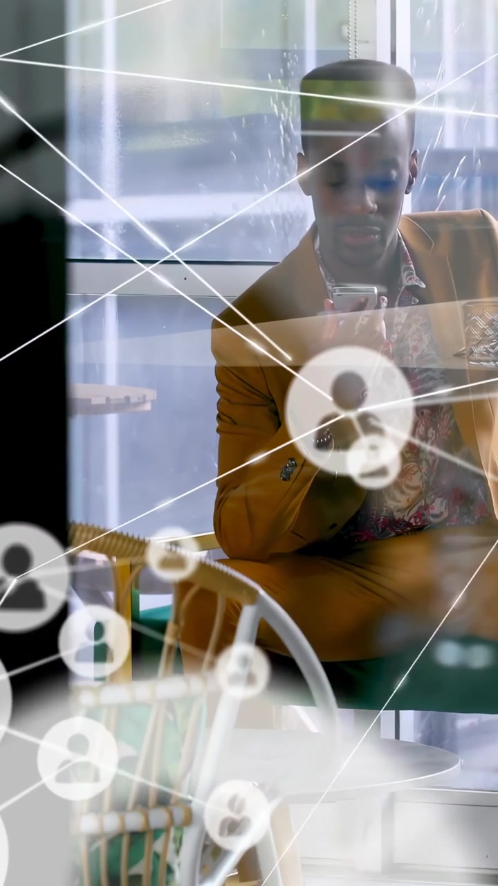 Vertical video: Man sitting in cafe tapping phone, starting overlay passing over man for business