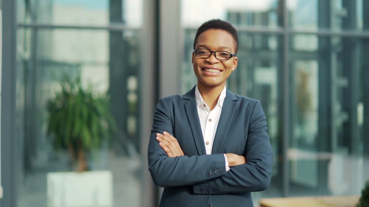 retrato de una mujer de negocios afroamericana segura y seria de pie con los brazos cruzados mirando a la cámara. al aire libre