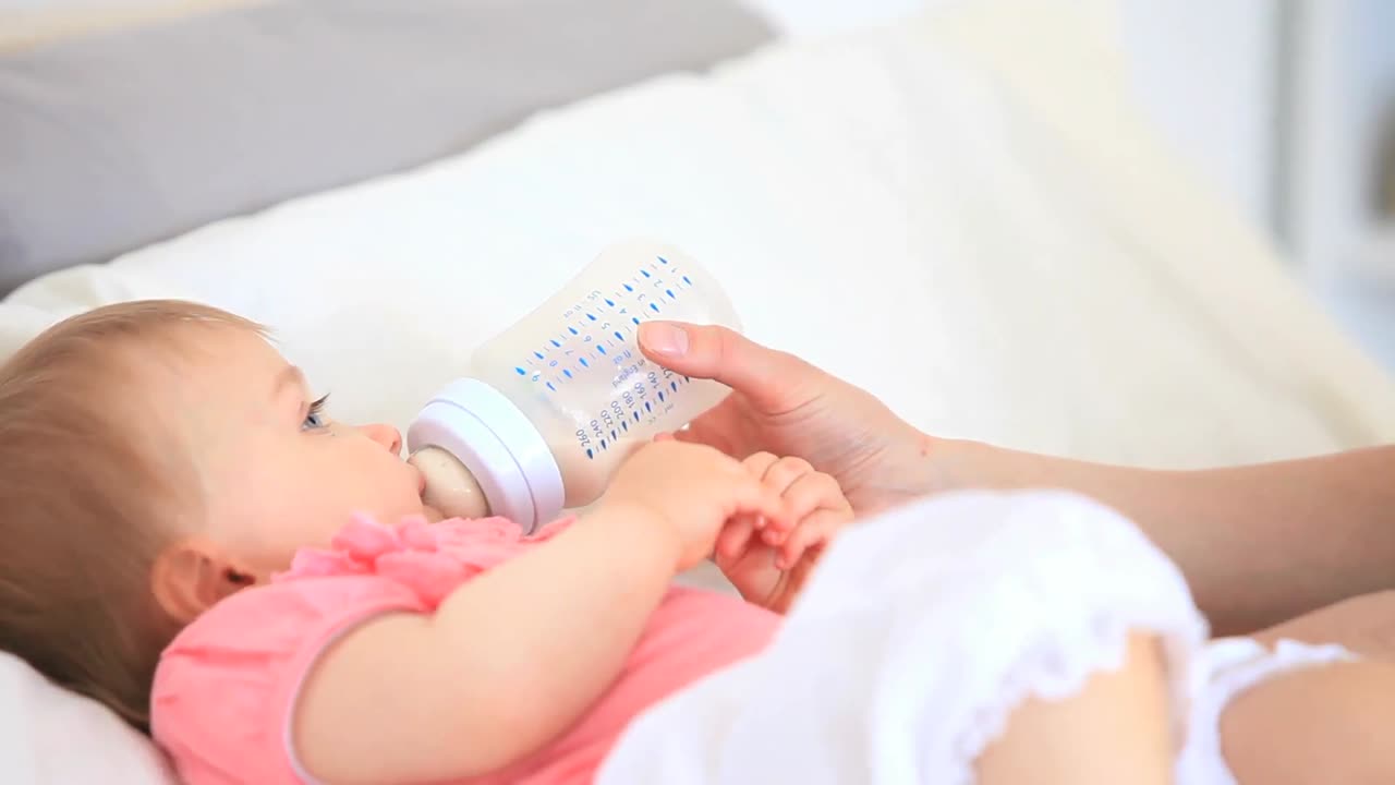 bebé lindo alimentado en la cama