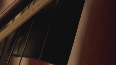 primer plano macro de violonchelo, arco de violonchelo, violonchelo y cuerdas