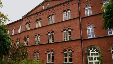 old-brick-house-with-large-white-windows-with-green-belly-in-the-window