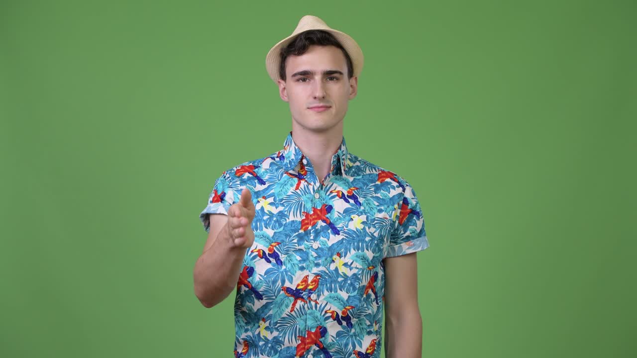 Young handsome tourist man giving handshake