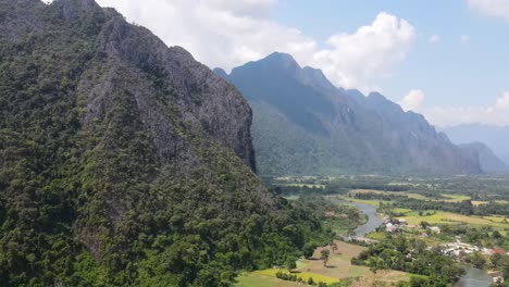 paralaje aéreo alrededor de la montaña para revelar campos agrícolas con el río nam song corriendo a través del paisaje