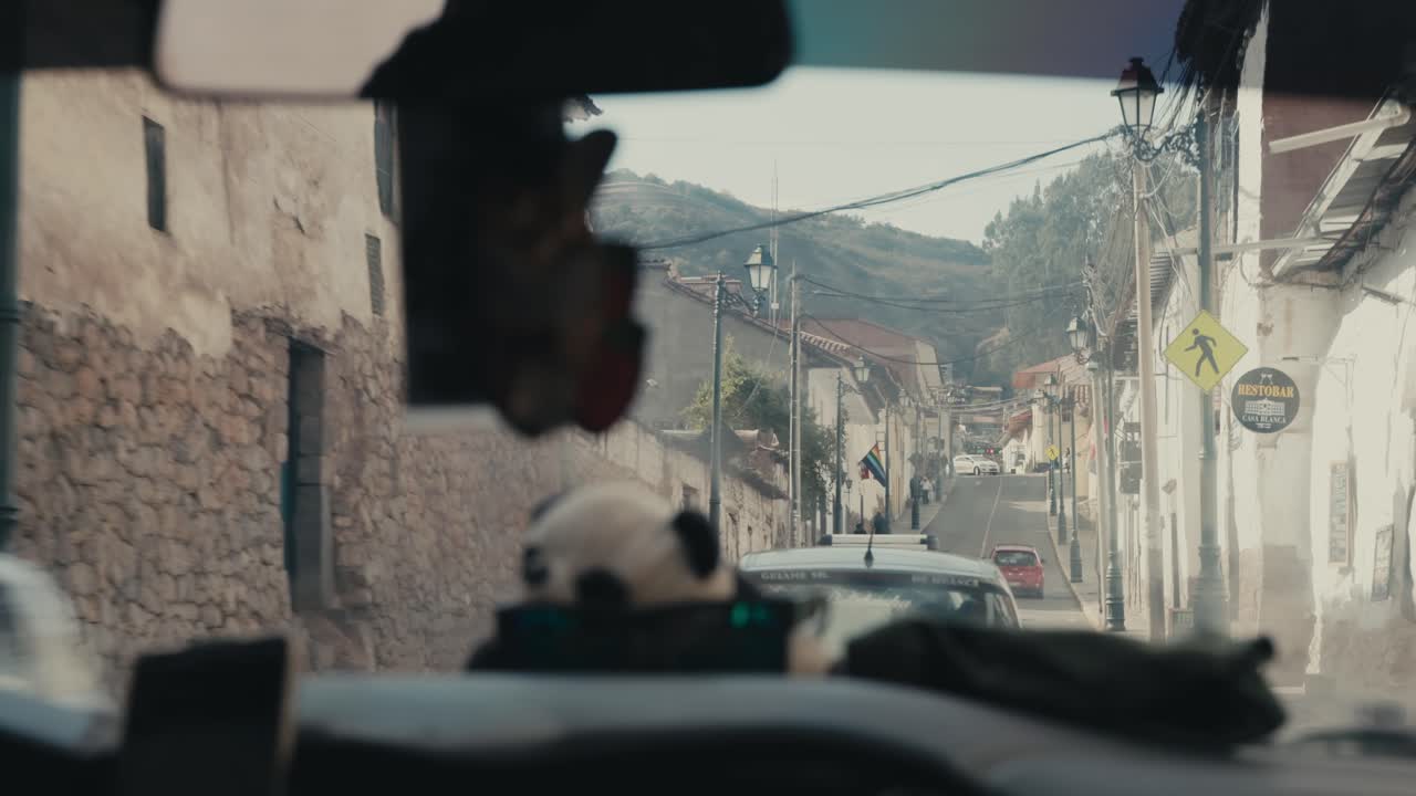 Driving Along Choqechaka Street With a Mountain Backdrop in Cusco, Peru - POV