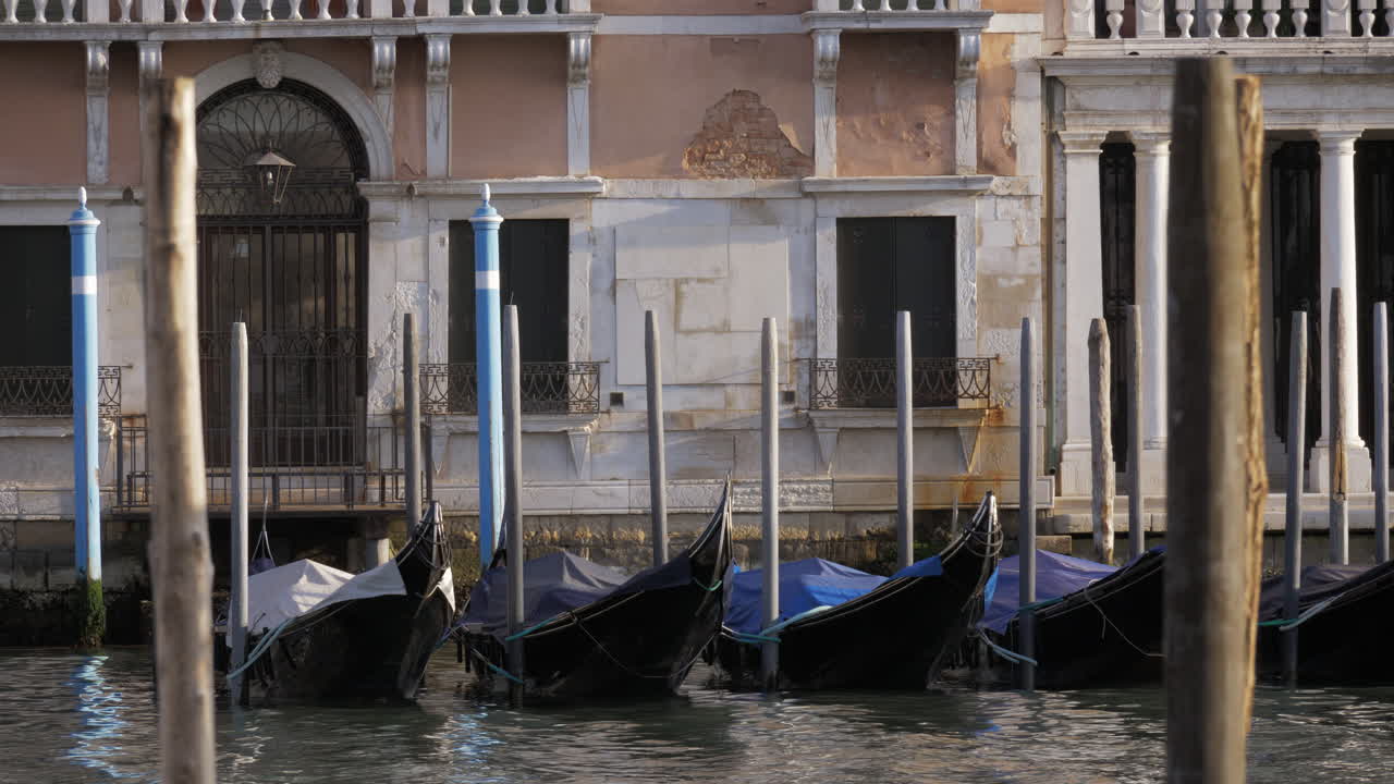 Góndolas negras vacías meciéndose en un muelle cerca de la hermosa fachada blanca
